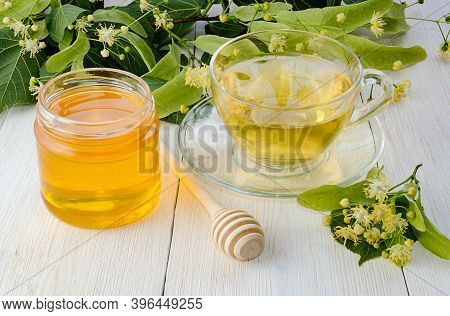 Jar Of Linden Honey, Cup Of Linden Tea And Branch With Linden Flowers On Wooden Table.