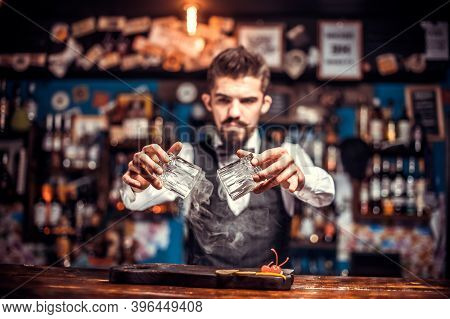 Charming Mixologist Pouring Fresh Alcoholic Drink Into The Glasses Behind Bar