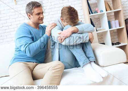 Father Sitting Near On Couch, Tries To Talk To His Son, But Problem Teenager Doesn't Want To Listen.