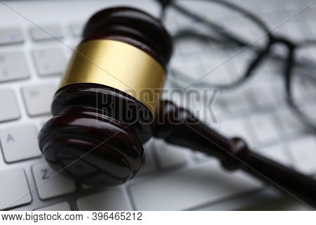 Brown Judge Hammer With Gold Ribbon Lie On White Comper Keyboard Closeup Background.
