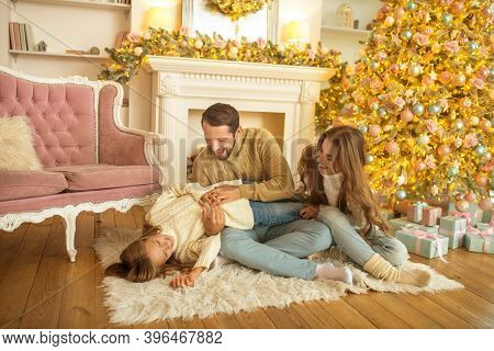 Young Family Feeeling Happy Opening Christmas Gifts