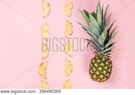 Ripe Juicy Pineapple On Pink Background And Dried Pineapple Wedges Around. Fruit Chips. Healthy Eati