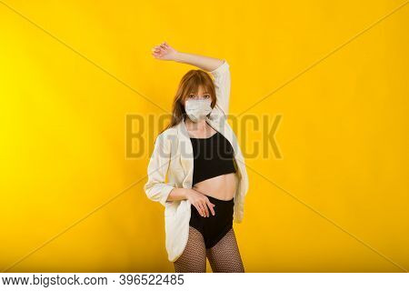 Female Strip Dancer In Yellow Studio In Protective Mask From Covid