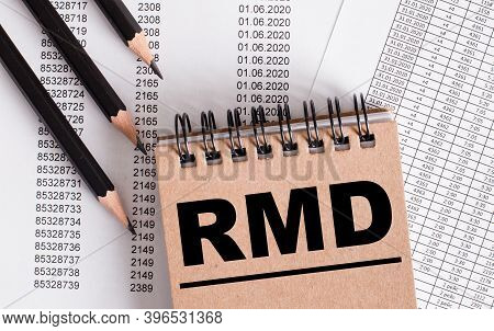 The Word Rmd Is Written On The Brown Notebook. Nearby Pencils