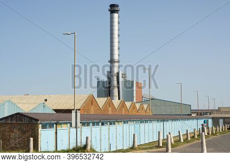 Seafront At Shoreham, West Sussex, England. With Beach Huts, Harbour Buildings And Power Station Chi