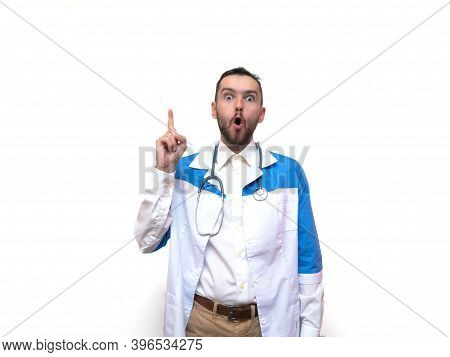 Portrait Of Doctor Man In Medical Coat Having Idea Moment Pointing Finger Up On White Studio Backgro