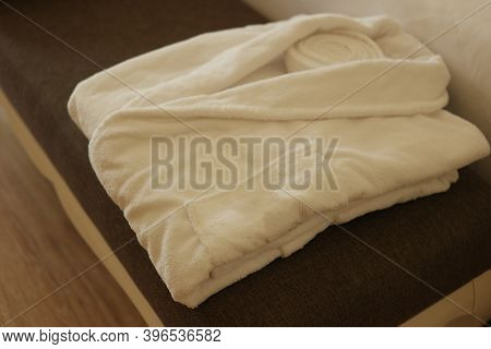 Folded Robe On Bed In Hotel Room. Soft Clean Bathrobe. Hotel Room Service Concept.