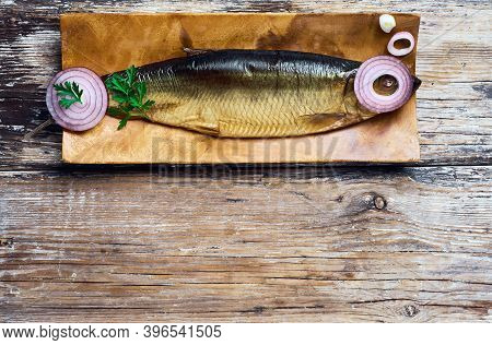 Smoked Herring On A Wooden Plate Top View, Dark Wooden Background With Copy Space. Ingredients For M