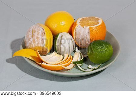 Fruit Citrus With Peels On Green Plate. Concept Reducing Food Waste