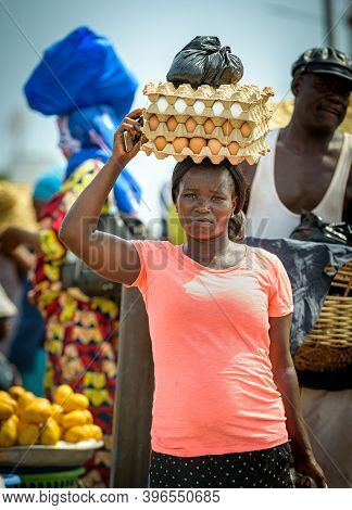 Accra,republic Of Ghana - April 30,2018:ghanaian Woman Carries A Box Of Eggs On Her Head