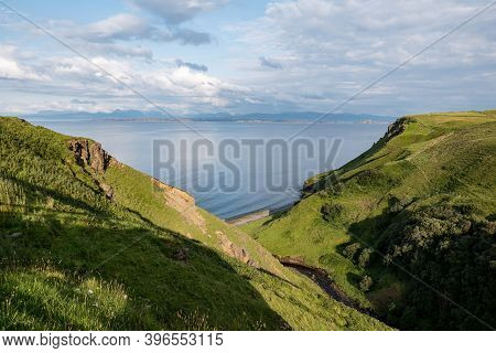 Green Scottish Landscape With Hills And Deep Gorge Near Staffin At Isle Of Skye With Pastures During
