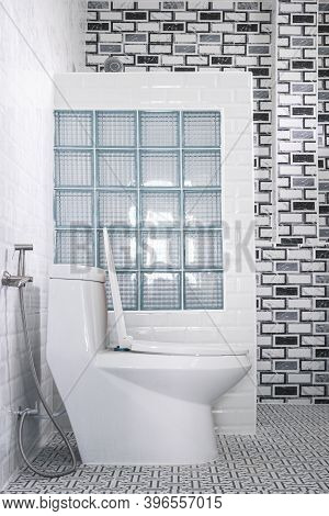 White Toilet Bowl And Glass Block In Partition Wall With Tile Wall Decoration Inside Of Modern Bathr