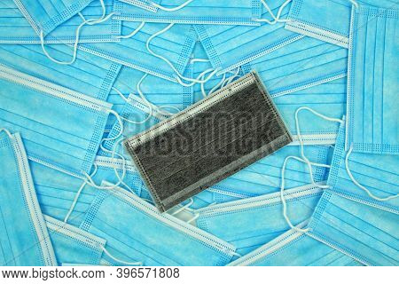 Pile Of Blue Mouth Nose Masks With One Black Mask - Medical Scapegoat Background