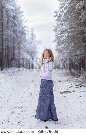 Portrait Blonde Girl Knitted Sweater Long Skirt Standing With Her Back Full Height Looking At The Ca