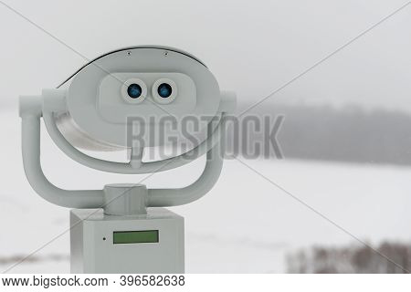 Binoculars On The Background Of A Frozen, Snow-covered River. Copy Space.
