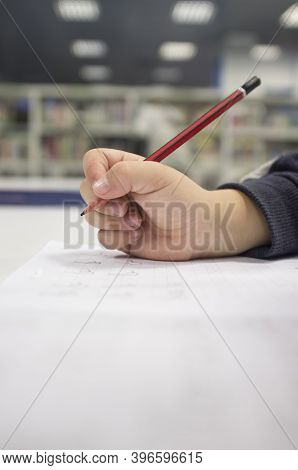 Pre-writter Child Boy Doing Calligraphy Exercises With Booklets. Selective Focus