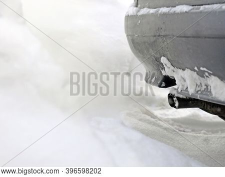 Exhaust Pipe Of Gray Car Fumes, Emits Gases Into  Snow And Contaminates The Environment. Focus On Pi