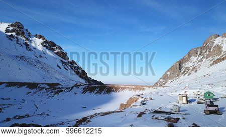 Snow Mountain Peaks With Rocks. View From Drone. In Places, You Can See Glaciers, Large Rocks And Ro