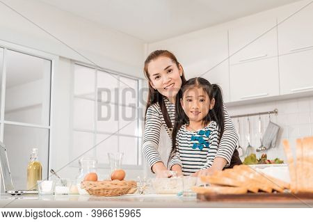 Happy Asian Mother And Daughter Is Making Flour For Bakery And Bread In Home Kitchen For Parenting C