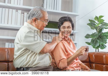 Senior Mature Man Is Taking Care Of Her Wife By Massaging Her While She Having Hot Tea Relaxation.