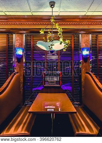 11/26/2020: A Restaurant Table Set With A Retro Looking Lanp Hanging Over And A Classic 1960s Jukebo