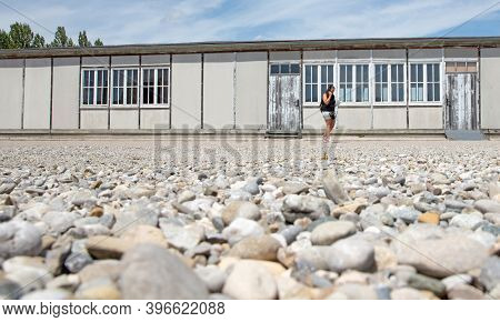 Dachau, Germany On July 13, 2020: Tourist With An Auduoguide In Dachau Concentration Camp
