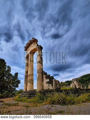 Close Upshot Of Ruins Of Tholos Of Ancient Greek Goddess Athena Pronaia In Delphi, Greece. Three Dor