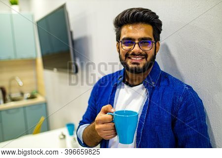 Arabian Man In Casual Dress Holning A Blue Cup And Looking Dreamly