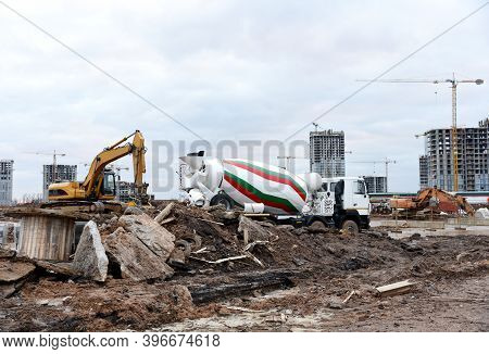 Excavator With Jaw Crusher Bucket For Crushes Concrete And Recycle Material. Cement Mixer Truck And 