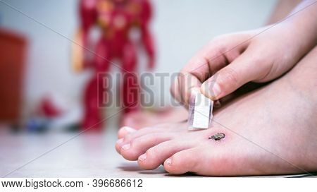 Child Putting Bandage Under Foot Wound, Band Aid Over Wound With Scab