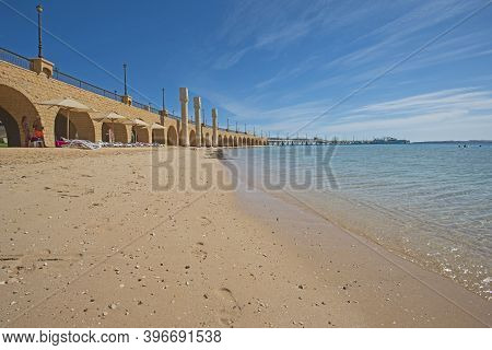 Closeup View Across An Empty Sandy Tropical Beach Resort Shoreline With Stone Stone Bridge Walkway A