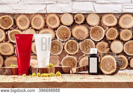 Two Colorful Cosmetic Tubes And Brown Plastic Bottle With Branding Area, Small Buds Of Blooming Yell