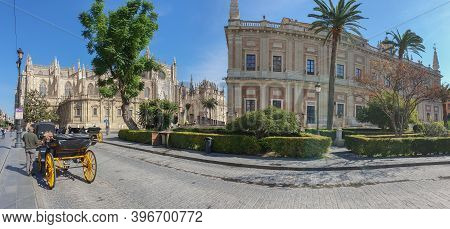 Seville, Spain - October 18. 2020: Horse Drawn Carriages At Plaza Triunfo With Tourists At The Back 