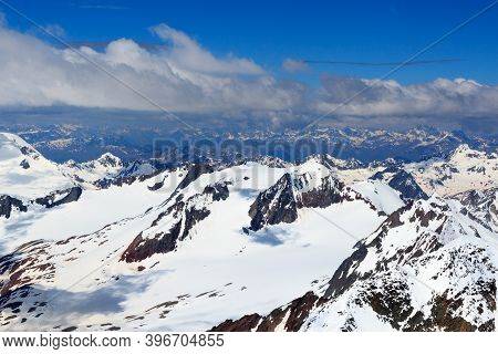 Mountain Snow Panorama On Main Chain Of The Alps Seen From Summit Wildspitze And Blue Sky In Tyrol A