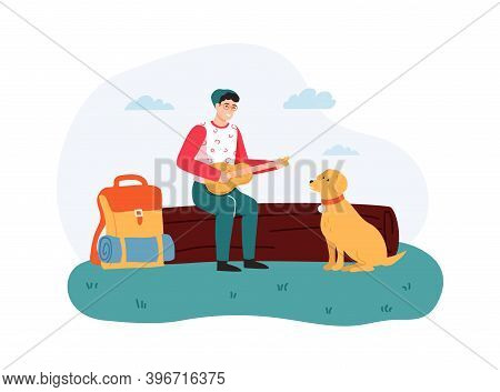 Boy Sitting On Log And Playing Guitar, Dog Sitting Near Hiker. Guy Having Summer Trip, Leisure Activ