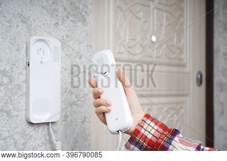 Woman Holds The Intercom Receiver In The Hand