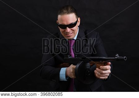 Mature Gangster In Sunglasses Dressed In Suit With Tommy Gun