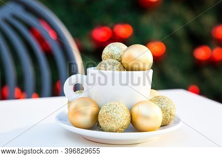 Horizontal Picture Of Coffee Cup With Golden Christmas Balls Inside And Around. Coffee Pair On White
