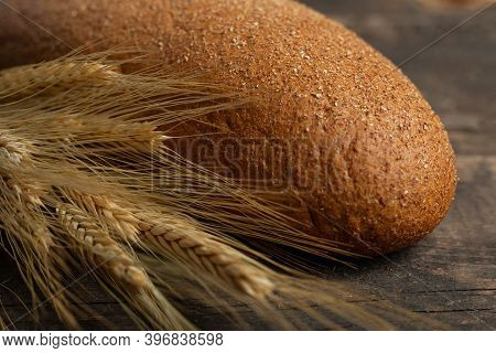 Freshly Baked Traditional Black Bread On A Wooden Table. Brown Coarse Bread Made From Shenitsa, Barl