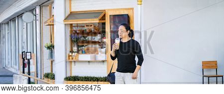 Asian Man In The Black T-shirt Holds The Bubble Ball Ice Milk Tea In Front Of The Shop On The Outdoo