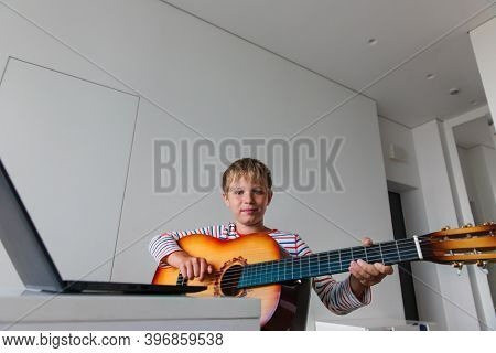 Kid Having Guitar Lesson Online, Teenage Boy On Remote Music Lesson