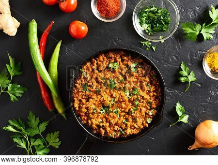 Keema Curry In Frying Pan Over Black Stone Background. Indian And Pakistani Style Dish. Top View, Fl
