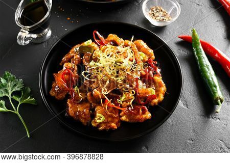 Spicy Garlic Fried Chicken (kkanpunggi). Asian Chicken In Sweet And Sour Sauce On Plate Over Black S