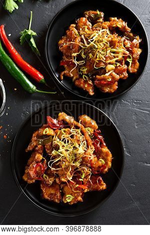 Spicy Garlic Fried Chicken (kkanpunggi). Asian Chicken In Sweet And Sour Sauce On Plate Over Black S