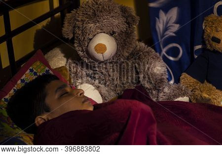 Boy Sleeping Cozily Tucked In Bed With Teddie Dolls Keeping Watch