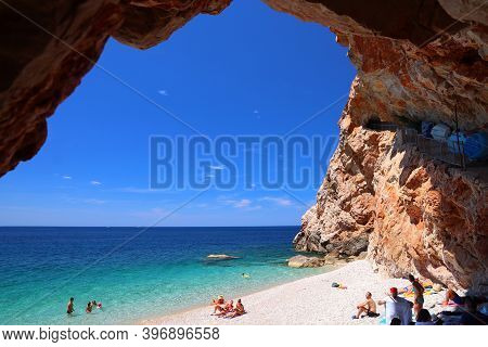 Konavle, Croatia - June 28, 2019: People Spend Vacation At Pasjaca Beach Below Cliffs In Konavle Reg