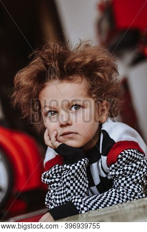 Funny Curly-haired Child Boy Expresses Funny Emotions Surprise Charismatic In A Sweater Black-and-wh