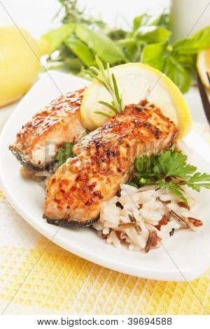 Izgara somon biftek pişmiş pirinç, otlar ve limon ile