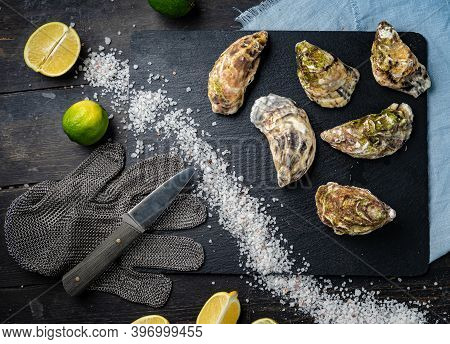 Fresh Oysters On A Black Stone Background. Top View. Oyster Dinner In Restaurant. Dark Background. S