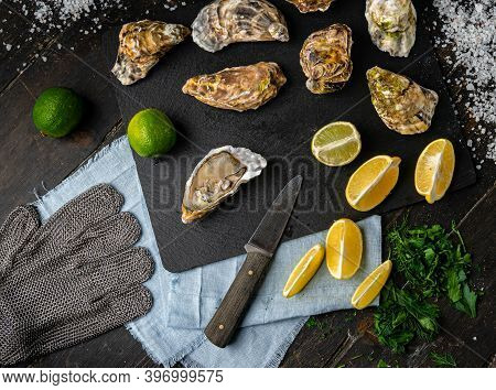 Fresh Oysters On A Black Stone Background. Top View. Oyster Dinner In Restaurant. Dark Background. S